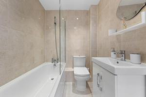 赫默尔亨普斯特德Cozy Apartment in Hemel Hempstead的浴室配有卫生间、浴缸和水槽。