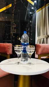 伊斯兰堡High Rise Executive Apartments Facing Centaurus Mall Islamabad的桌子上摆放着一瓶水和两杯眼镜
