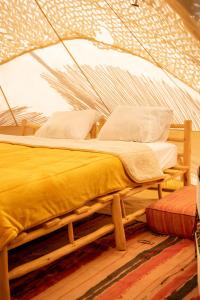 马拉喀什La Ferme des Tipis Marrakech的帐篷内一间卧室,配有一张床