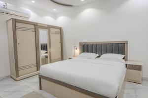 麦地那Luxurious Family 3 Bedroom Apartments 10 Mins Drive to Al-Masjid Nabawi - Qaswarah residence的卧室配有一张白色大床和镜子