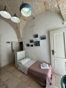 佩兹迪格雷科Casa Mida - Guest House的一间卧室配有床和带灯的天花板
