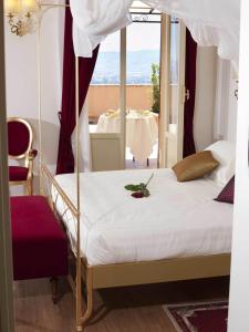 阿西西吉欧托温泉酒店的一间卧室设有一张天蓬床,享有桌子的景色
