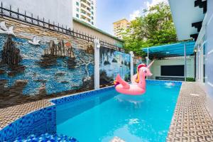 胡志明市KN3 Holiday Villa的一座游泳池,在一座建筑前设有粉红色充气面板