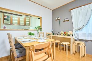 东京Comfy Home Koiwa的厨房以及带木桌和椅子的用餐室。