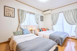 东京Comfy Home Koiwa的带2扇窗户的客房内的2张床