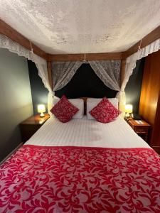 剑桥索伦托酒店&餐厅的红色和白色的床,配有两个红色枕头