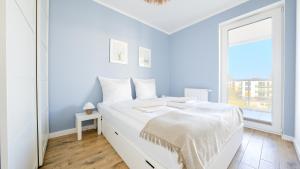 贡斯基Apartamenty Sun & Snow Gąski的白色的卧室设有白色的床和窗户。