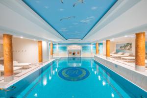 宾茨罗嘉德温泉海滩酒店的一个带蓝色天花板和海豚绘画的大型游泳池