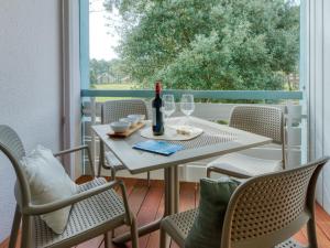 拉卡诺奥肯Apartment Village Cheval Spa Résidences-1 by Interhome的露台上的一张桌子和一瓶葡萄酒