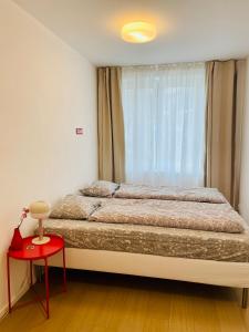 波杰布拉迪Královské apartmá kolonáda的一间卧室设有一张大床和一张红色的桌子。