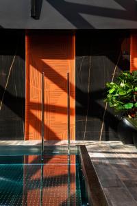 布雷斯特Oceania Le Conti的一座拥有橙色墙壁和植物的游泳池