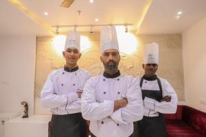 纳特杜瓦拉The RRA Kabras Hotel, Nathdwara的三名厨师站在厨房里,手臂交叉