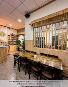岘港Hồng Châu Hotel的用餐室配有大型木桌和椅子
