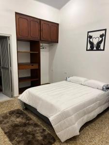 拉多拉达HOTEL GANADERO的一间卧室配有一张大床和一个木制橱柜