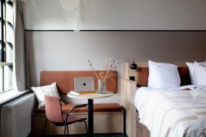哥本哈根Bob W Østerbro Copenhagen的一间卧室配有一张床和一张带笔记本电脑的桌子