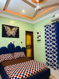 瓦加杜古Villa meublée climatisé en cours unique的卧室配有一张床上,墙上挂着蝴蝶