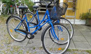 韦斯特维克丁香度假屋的一辆蓝色自行车,车上有一个篮子,停在人行道上