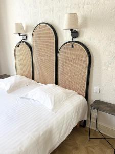 波尔多Hôtel La Tour Intendance的一间卧室配有一张带两个床头板和一张桌子的床。
