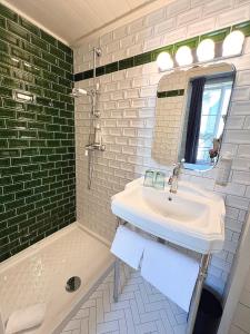 波尔多Hôtel La Tour Intendance的浴室配有盥洗盆、镜子和浴缸