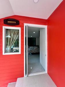 三帕兰MrT Riverside Sampran มิสเตอร์ที โฮมสเตย์-ทองกวาว的一道红色的墙,门进入房间