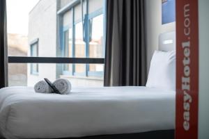 鹿特丹鹿特丹市中心便捷酒店的一间卧室配有一张床,并备有2个拖鞋