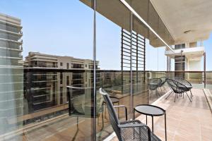 阿布扎比Silkhaus Luxurious 1 BDR Next to Golf Course的大楼内带桌椅的阳台
