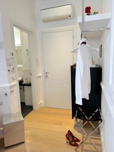 佛罗伦萨圭恰迪尼24号住宿加早餐旅馆的浴室设有架子上的白色长袍和红色鞋