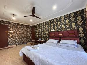 斯利那加Hotel Crescent的一间壁纸客房内的大床卧室