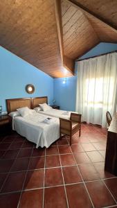 BenquerenciaCasa Rural Piedras de Benquerencia的一间卧室设有两张床和木制天花板