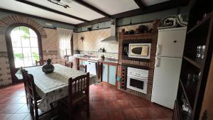 BenquerenciaCasa Rural Piedras de Benquerencia的厨房配有桌子和白色冰箱。