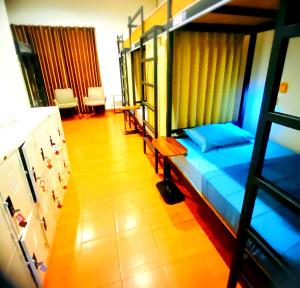 Ban Sao ThongThree Hostel at Night Market Pakchong的一间卧室配有一张带蓝色床单的双层床,铺有木地板。