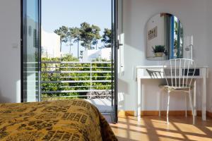 帕尔梅拉Villa Serena -your exclusive private swimming pool的一间带一张床和一张书桌的卧室以及一个阳台