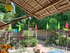 安蒂波洛YOUMEBED MOTOR INN at Kambal Kubo Resthouse的一个带木栅栏和彩色遮阳伞的花园