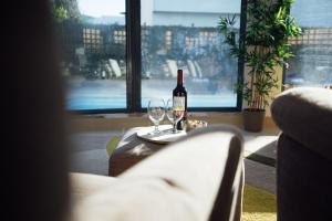 帕尔梅拉Villa Serena -your exclusive private swimming pool的一张桌子上放着一瓶葡萄酒,放上两杯