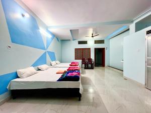瓦拉纳西Trilok Residency - Dashashwamedh Varanasi的一间卧室设有两张床和蓝色的墙壁