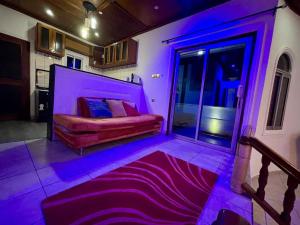杜阿拉Mini villa cosy et discrete的一间卧室配有一张紫色照明床