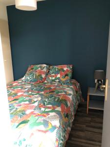 Signy-le-Petitcottage chaleureux dans domaine privé的卧室内一张带五颜六色棉被的床