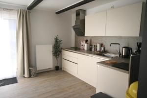 LütowFerienwohnung für sechs Personen - b57584的厨房铺有木地板,配有白色橱柜。