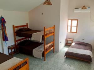 普拉亚斯Playas的客房设有三张双层床和一扇窗户。