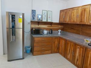 普拉亚斯Playas的厨房配有木制橱柜和不锈钢冰箱。