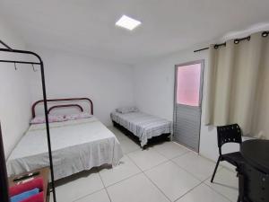 奥林达KITNET EM OLINDA CASA CAIADA A 50 MT DA PRAIA的卧室配有床、椅子和窗户。