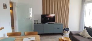 诺德奈Dünenrose Seegras Nr 41的客厅配有梳妆台上的平面电视