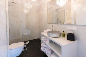什切青Kaleo apartments - Hanza Tower的浴室配有盥洗盆、卫生间和浴缸。
