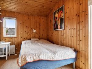 措斯泰兹Holiday Home Dolores - all inclusive - 200m from the sea by Interhome的卧室配有一张床铺,位于带木墙的房间内