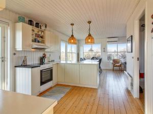斯卡恩Holiday Home Carstina - all inclusive - 400m from the sea by Interhome的厨房铺有木地板,配有白色橱柜。