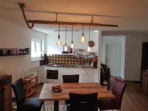 库尔瓦尔登Apartment Haus Bettina Fischer by Interhome的一间带木桌和椅子的厨房以及一间用餐室