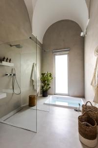 莱切Palazzo Console的一间带玻璃淋浴和窗户的浴室