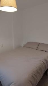 格拉纳达Apartamento moderno a 1km de Granada的卧室配有带灯的白色床