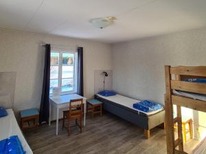永比Södra Ljunga Vandrarhem的客房设有两张床、一张桌子和一个窗户。