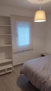 格拉纳达Apartamento moderno a 1km de Granada的一间卧室配有床、台灯和架子